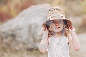 Happy little girl wearing a hat outdoors