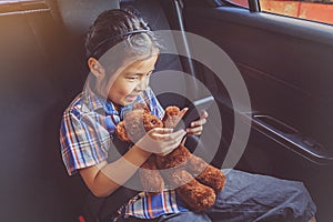 Happy little girl wearing seatbelts in car