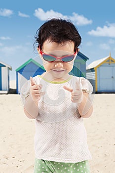 Happy little girl wearing sunglasses on the beach