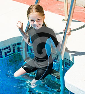 Happy little girl in a wetsuit