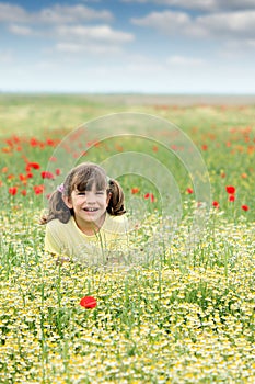 Happy little girl on wildflowers meadow