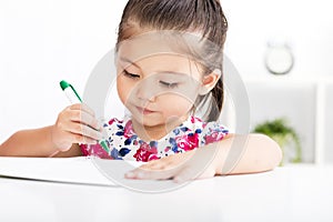 Happy little girl writing in notebook