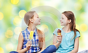 Happy little girls eating ice-cream over green