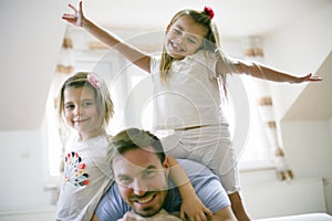 Happy little girls with father at home.