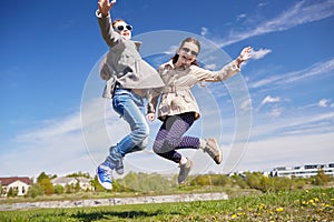 Happy little girls jumping high outdoors