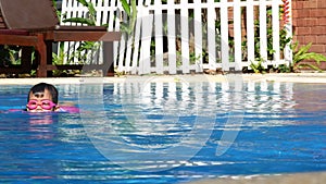 Happy little girls learn to swim in the pool with her mother on a hot summer day during vacation.