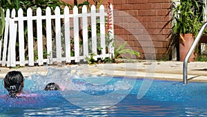 Happy little girls learn to swim in the pool with her mother on a hot summer day during vacation.