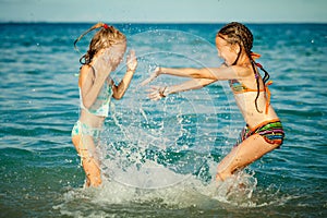 Happy little girls playing at the beach
