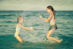 Happy little girls playing at the beach