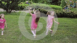 Happy little girls playing in garden and playing bubbles