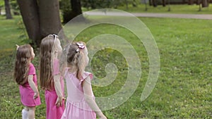 Happy little girls playing in garden and playing bubbles