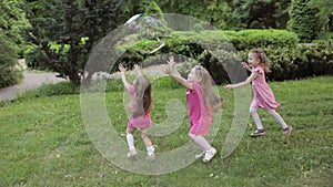 Happy little girls playing in garden and playing bubbles