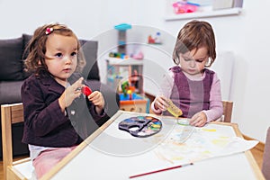 Happy little girls, preschooler, painting with water color, selective focus