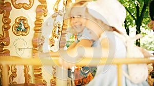 Happy little girls ride a retro carousel on a sunny summer day in Grenoble, France