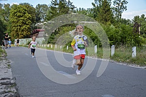 Happy little girls running in race on the street outdoors