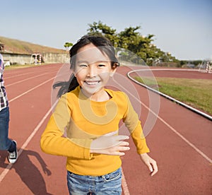 Happy little girls running on the track