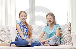 Happy little girls sitting on sofa at home