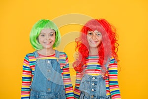 Happy little girls smiling faces. Anime fan. Cheerful friends in bright colorful wigs. Anime cosplay party concept