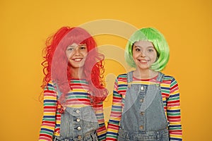 Happy little girls smiling faces. Anime fan. Cheerful friends in bright colorful wigs. Anime cosplay party concept