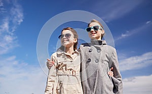 Happy little girls in sunglasses hugging outdoors