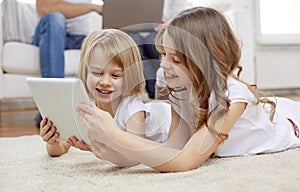 Happy little girls with tablet pc computer at home