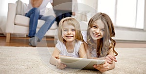 Happy little girls with tablet pc computer at home