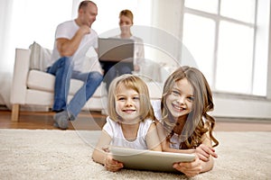 Happy little girls with tablet pc computer at home