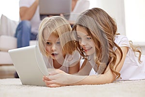 Happy little girls with tablet pc computer at home