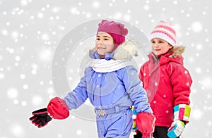 Happy little girls in winter clothes outdoors