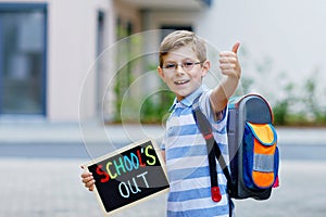 Happy little kid boy with backpack or satchel. Schoolkid on the way to school. Healthy adorable child outdoors With