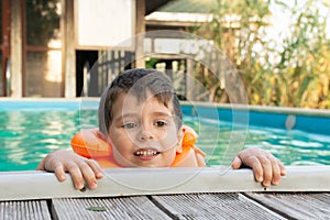 Happy little kid boy having fun in an swimming pool. Active happy preschool child learning to swim.