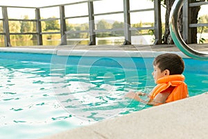 Happy little kid boy having fun in an swimming pool. Active happy preschool child learning to swim.