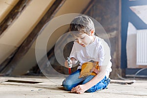 Happy little kid boy helping with toy tools on construction site. Funny child of 7 years having fun on building new