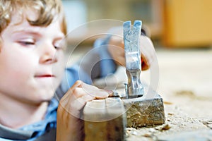 happy little kid boy helping with toy tools on construction site. Funny child of 7 years having fun on building new