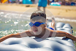 Happy little kid  lying on air water mattress in sea