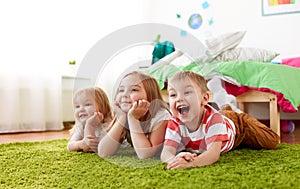 Happy little kids lying on floor or carpet