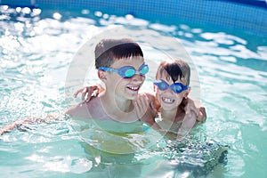 Happy little kids playing in swimming pool