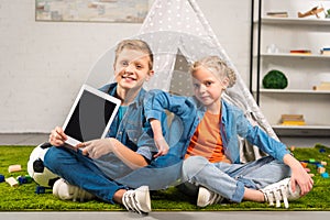 happy little kids showing digital tablet with blank screen near tent