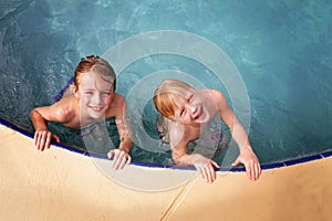 Happy Little Kids Smiling as They Swim in the Family Swimming Pool