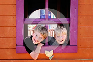 Happy Little Kids Smiling at the Park as they Peek out the Window of a Clubhouse Fort