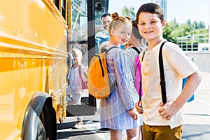 happy little pupils entering school bus