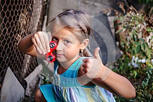 Happy little rural girl with a spinner in her hand