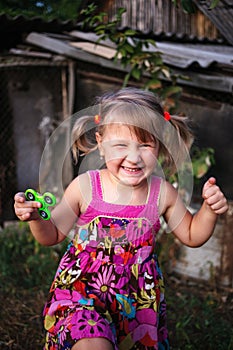 Happy little rural girl with a spinner in her hand