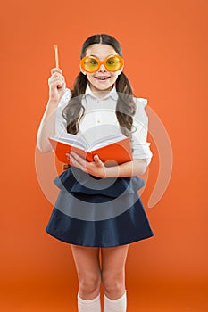 Happy little schoolgirl ready for lesson. Cute child with book. Only wisdom knowing you know nothing. Study foreign