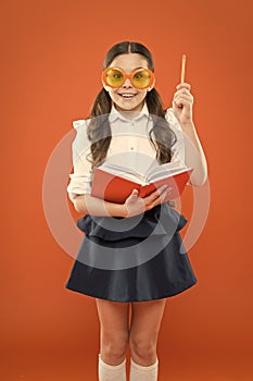 Happy little schoolgirl ready for lesson. Cute child with book. Only wisdom knowing you know nothing. Study foreign