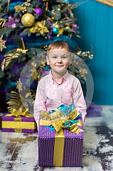 Happy little smiling boy holds christmas gift box