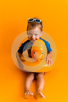 happy little smiling child swimmer sport boy wear sun glasses swimsuit, Kid Inflatable swimming ring yellow duck point