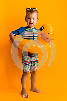 happy little smiling child swimmer sport boy wear sun glasses swimsuit, Kid Inflatable swimming ring yellow duck point