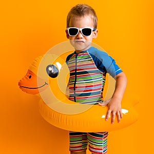 happy little smiling child swimmer sport boy wear sun glasses swimsuit, Kid Inflatable swimming ring yellow duck point
