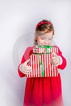 Happy little smiling girl with christmas gift boxes